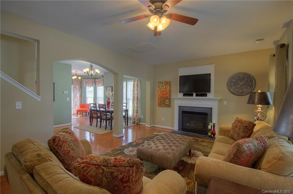 8813 Washam Potts Road Cornelius, NC 28031 - Photo 3 of 24 a living room with furniture a fireplace and a flat screen tv