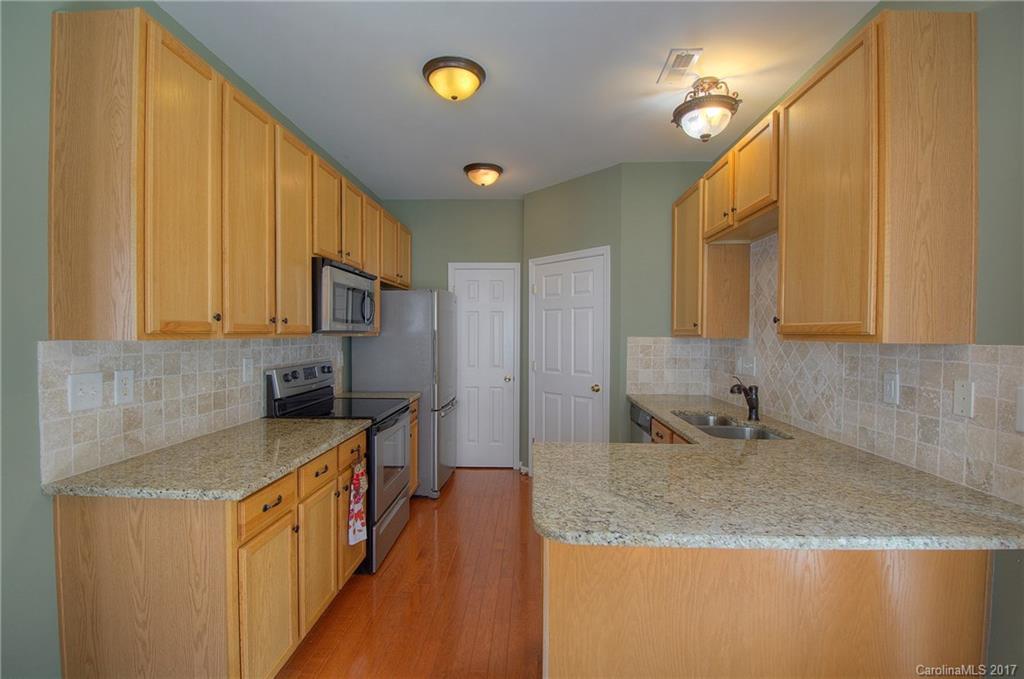 8813 Washam Potts Road Cornelius, NC 28031 - Photo 8 of 24 a kitchen with stainless steel appliances granite countertop a sink a stove counter space and cabinets