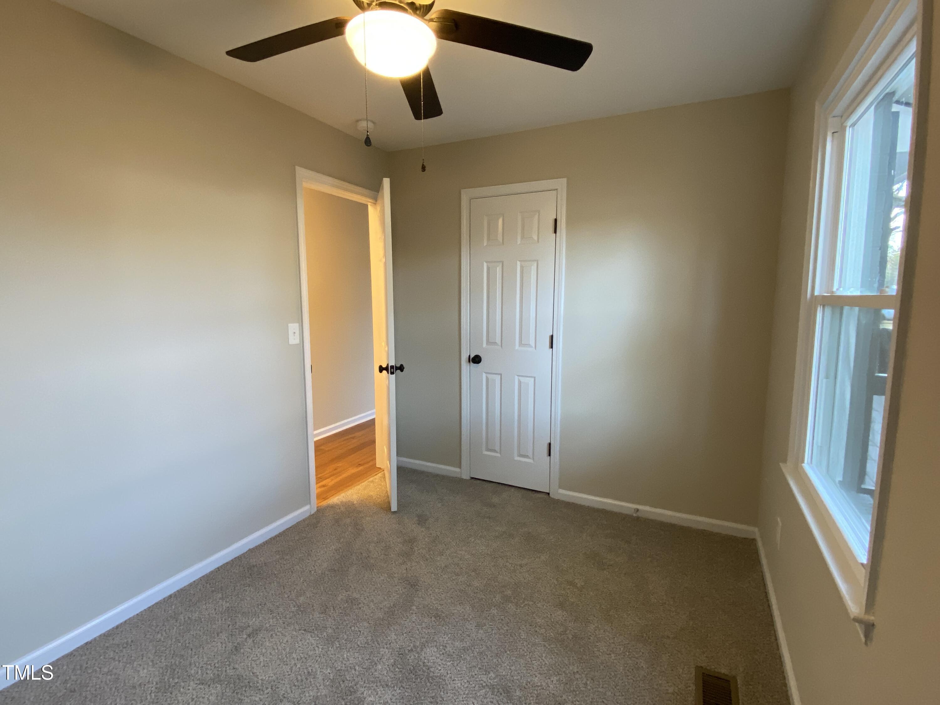 110 Sycamore Street Dunn, NC 28334 - Photo 12 of 28 an empty room with closet and a chandelier fan