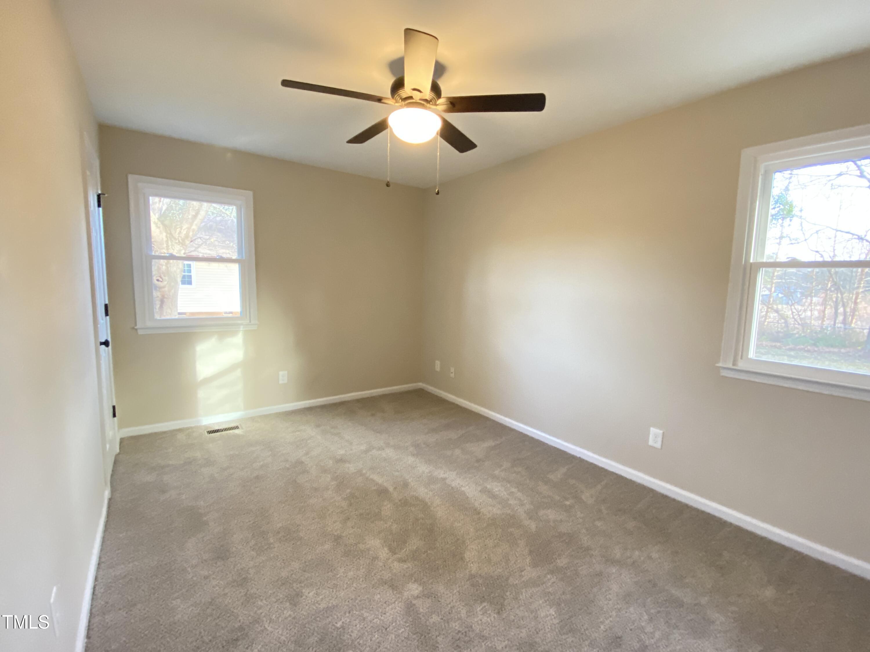 110 Sycamore Street Dunn, NC 28334 - Photo 19 of 28 an empty room with a window and a fan