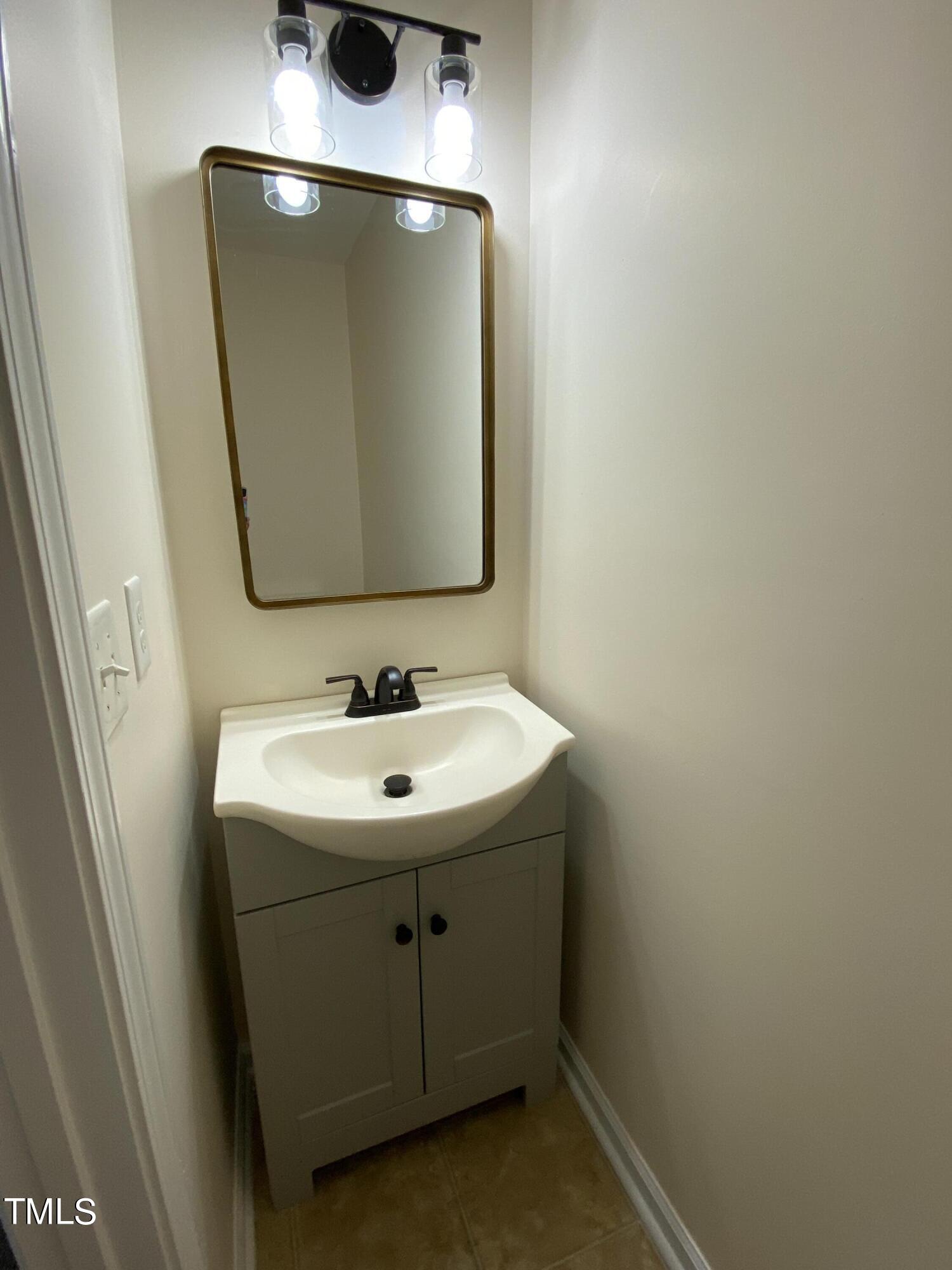 110 Sycamore Street Dunn, NC 28334 - Photo 21 of 28 a bathroom with a sink and mirror