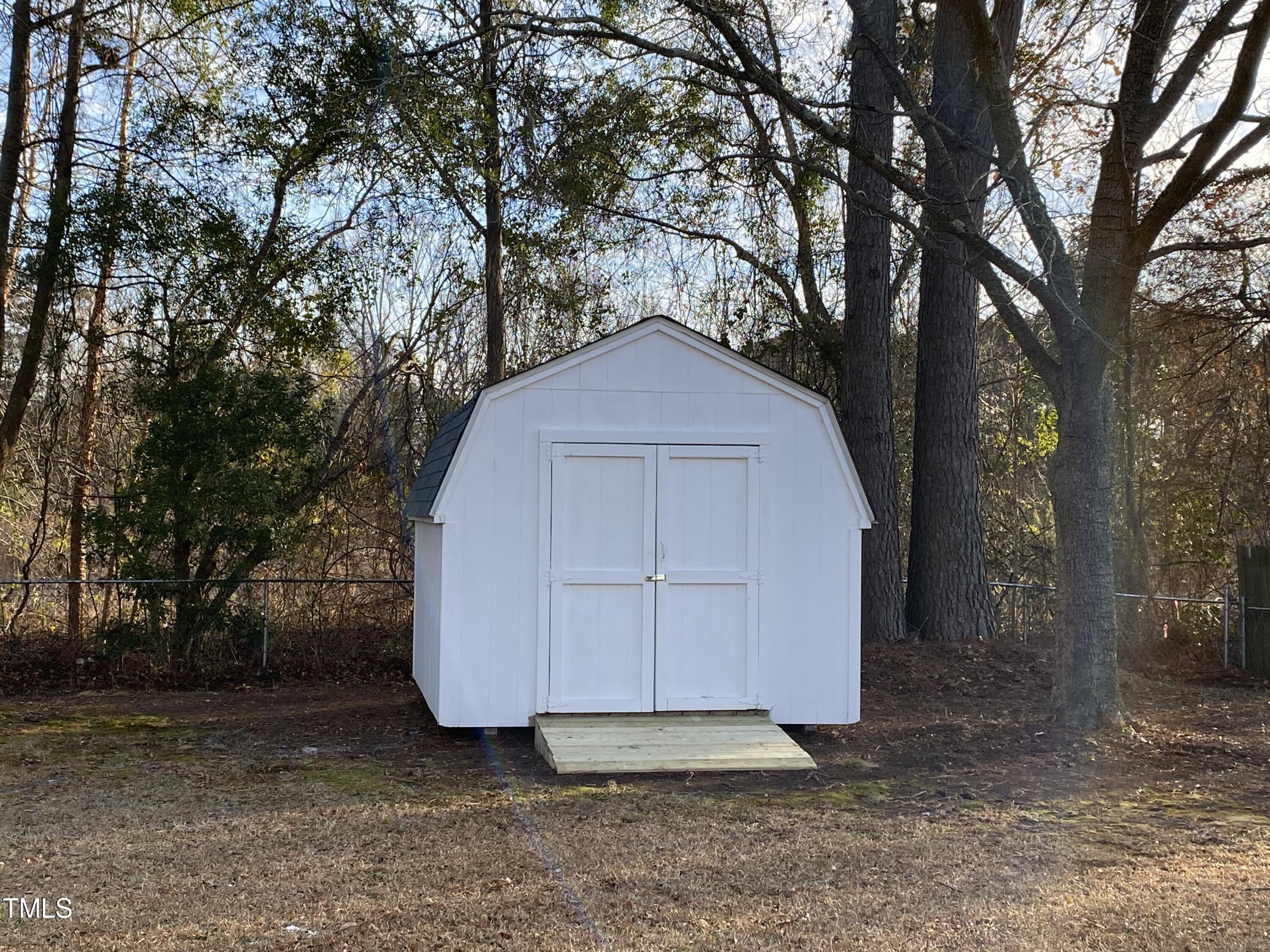 110 Sycamore Street Dunn, NC 28334 - Photo 27 of 28 a view of backyard with large trees and wooden fence