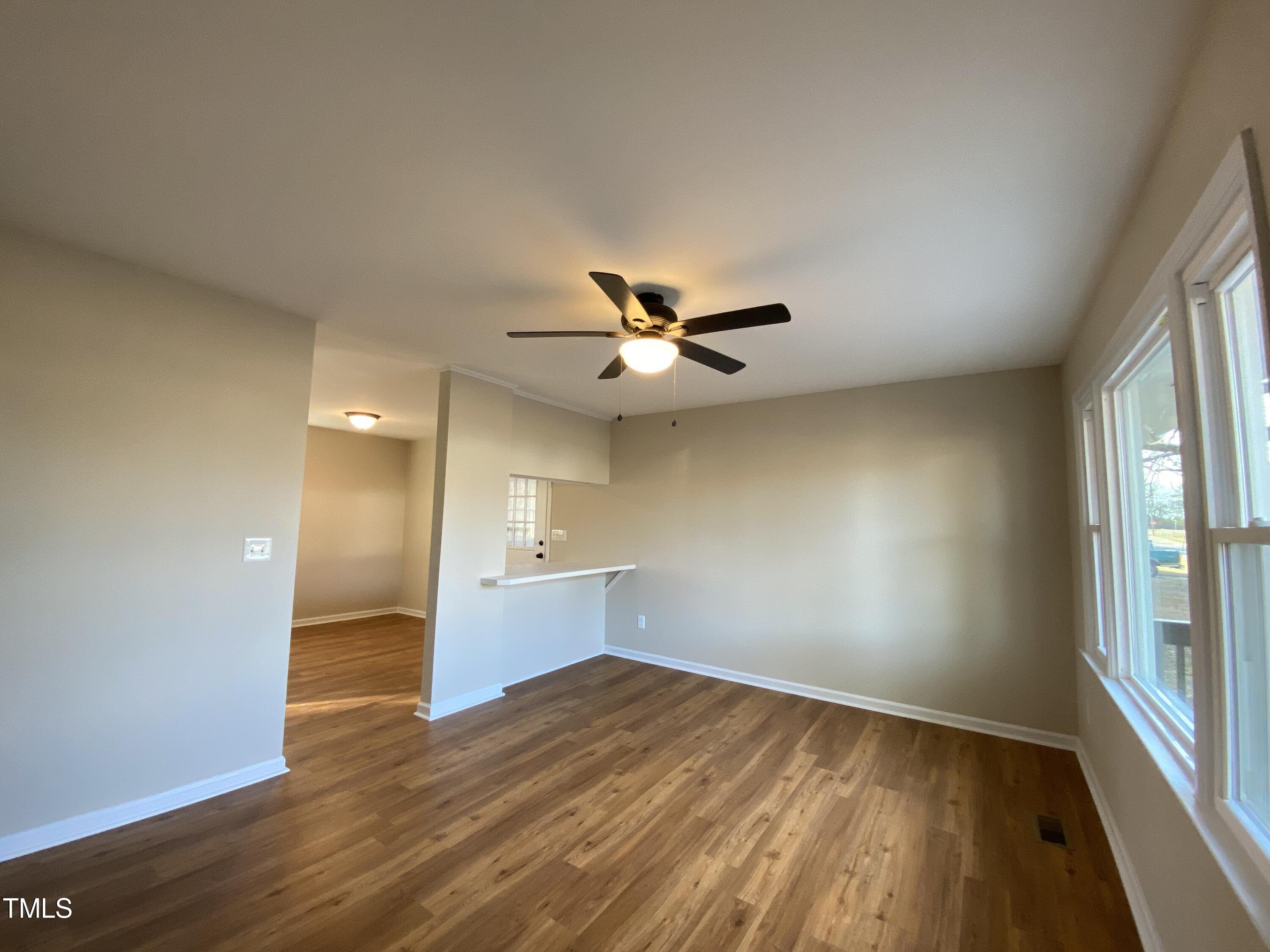 110 Sycamore Street Dunn, NC 28334 - Photo 3 of 28 an empty room with wooden floor fan and windows