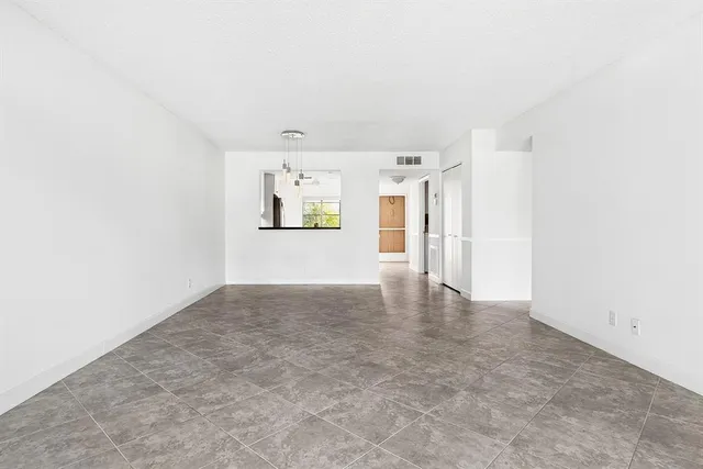 a view of a big room with wooden cabinet and windows