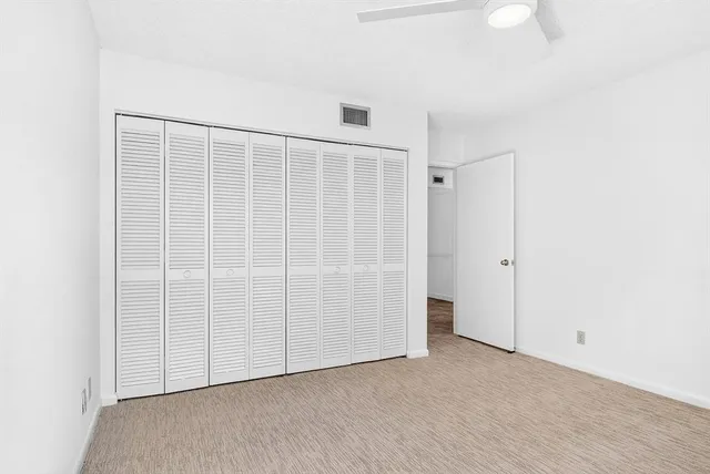 a view of an empty room with closet