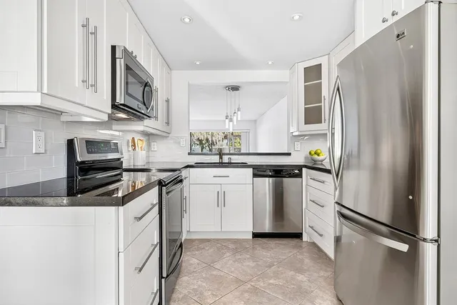 a kitchen with white cabinets and stainless steel appliances