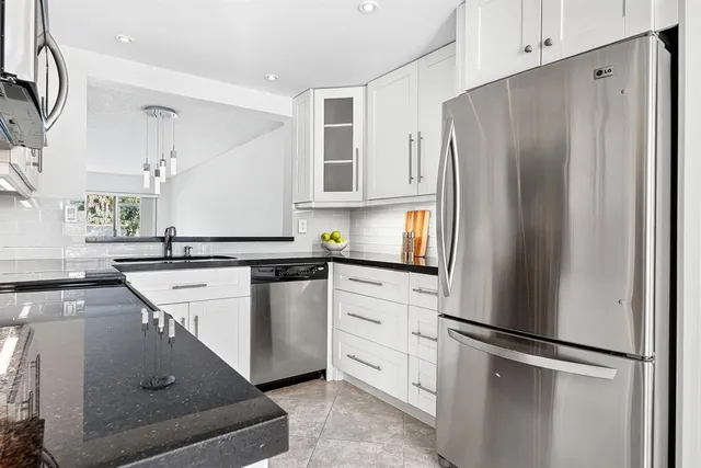 a kitchen with stainless steel appliances a refrigerator sink and cabinets