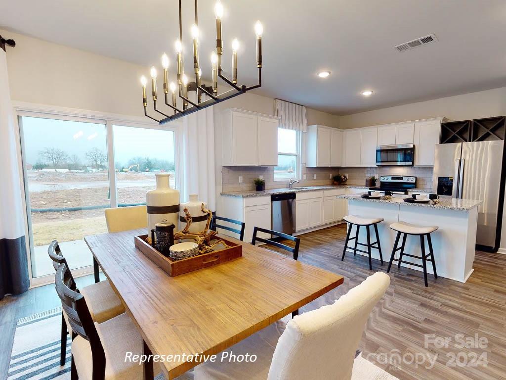 1207 Dan River Southwest, Unit 159 Concord, NC 28027 - Photo 3 of 13 a kitchen with a dining table and chairs