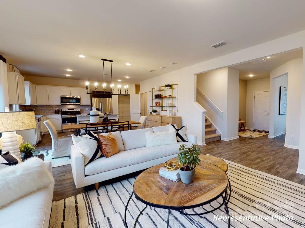1207 Dan River Southwest, Unit 159 Concord, NC 28027 - Photo 4 of 13 a living room with furniture kitchen view and a chandelier