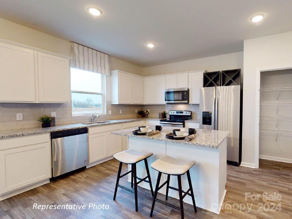 1207 Dan River Southwest, Unit 159 Concord, NC 28027 - Photo 6 of 13 a kitchen with stainless steel appliances a stove a sink a microwave a refrigerator and cabinets