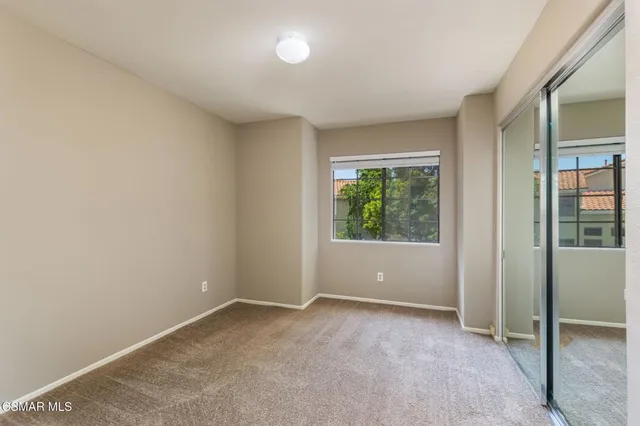 an empty room with windows and closet