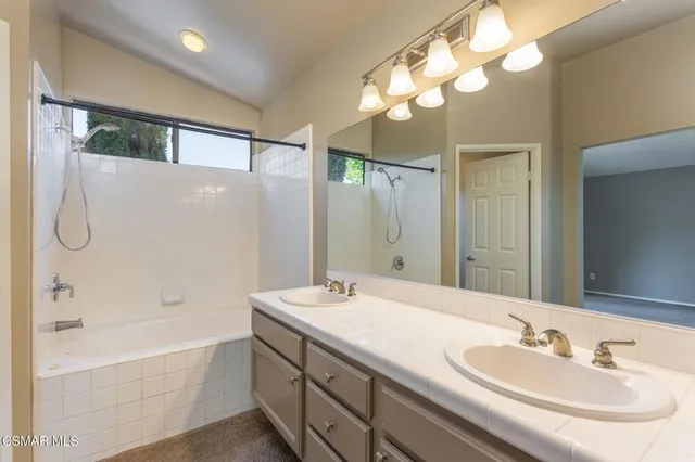 a bathroom with a bath tub sink and mirror