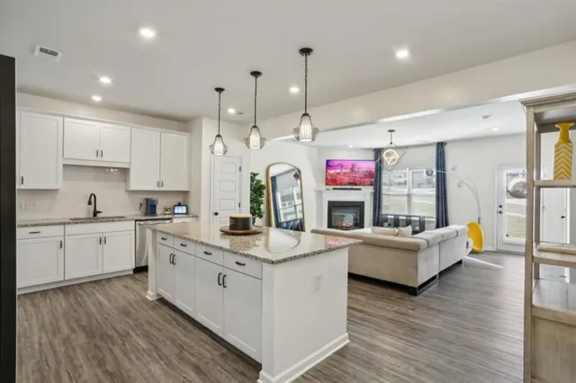 a large white kitchen with kitchen island a large counter space a sink stainless steel appliances and cabinets