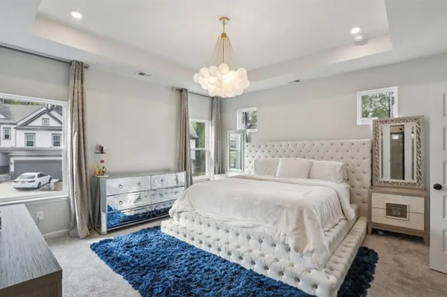a spacious bedroom with a bed and a chandelier