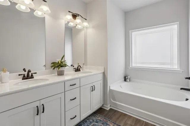 a bathroom with a tub a sink and mirror