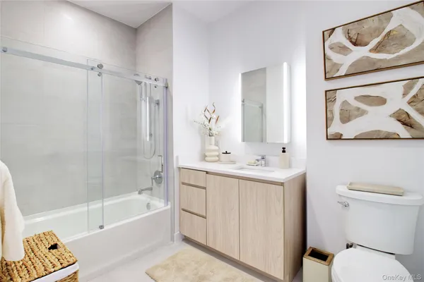 a bathroom with a toilet sink vanity tub and shower