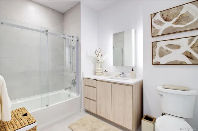 a bathroom with a toilet sink vanity tub and shower
