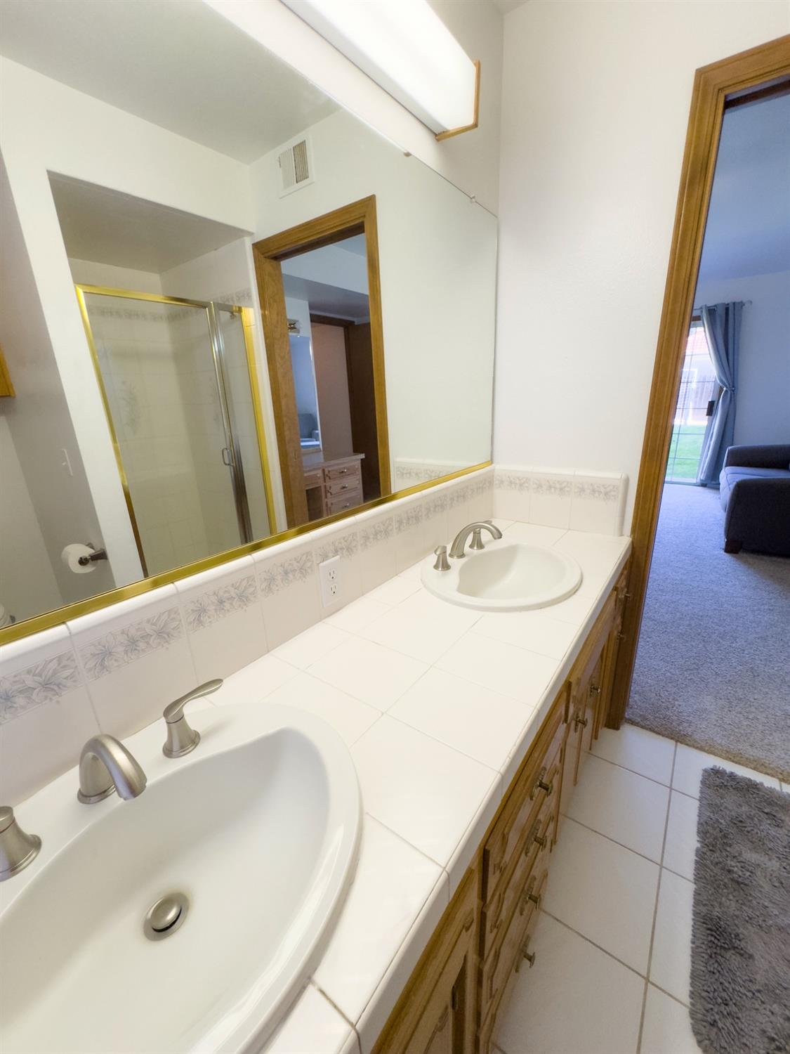 2544 Sterling Avenue Sanger, CA 93657 - Photo 22 of 27 a en suite bathroom with a double vanity sink and a mirror