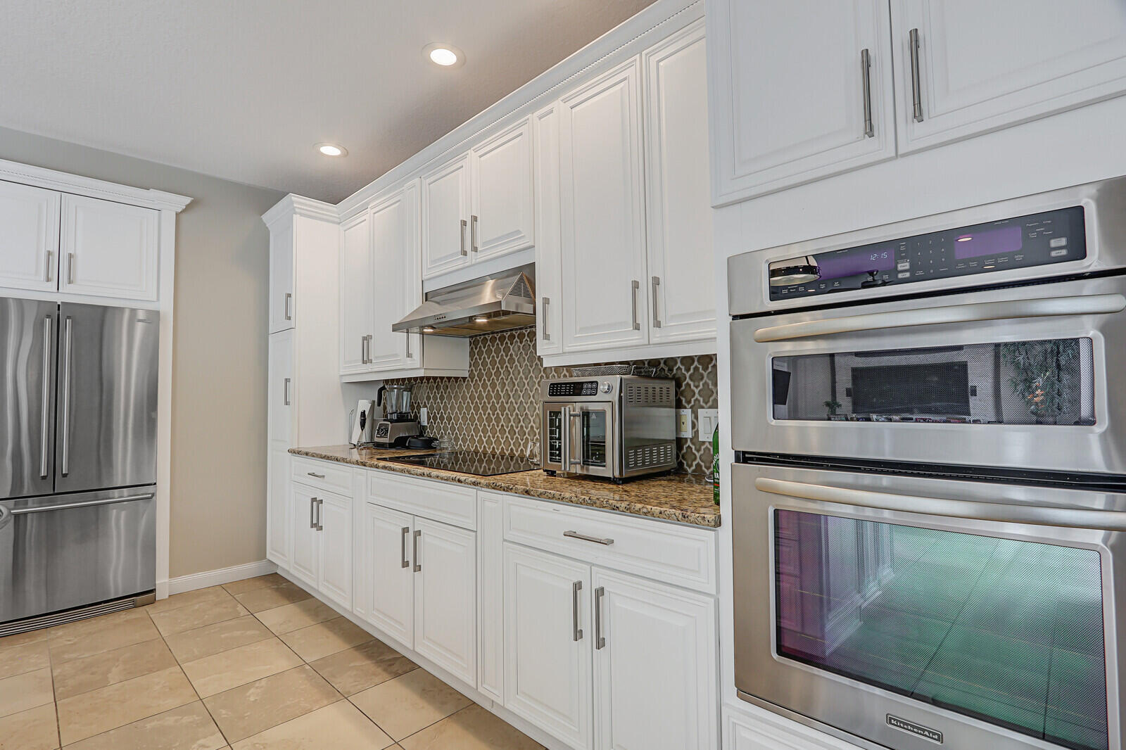 101 St Pierre Way Jupiter, FL 33458 - Photo 22 of 57 a kitchen with granite countertop white cabinets stainless steel appliances and a counter space