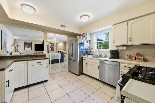 a kitchen with white cabinets and appliances