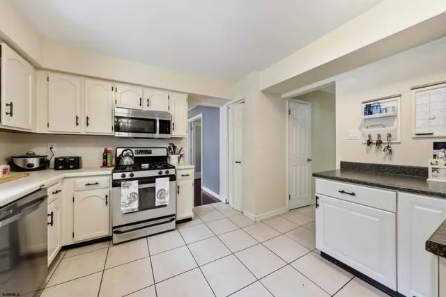 a kitchen with white cabinets appliances and a sink