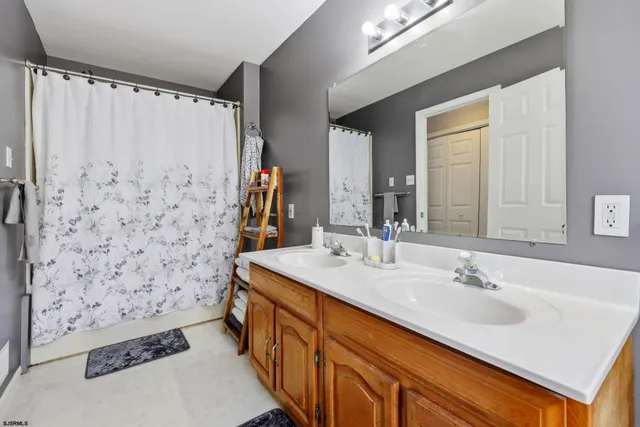 a bathroom with a sink a mirror and a shower curtain