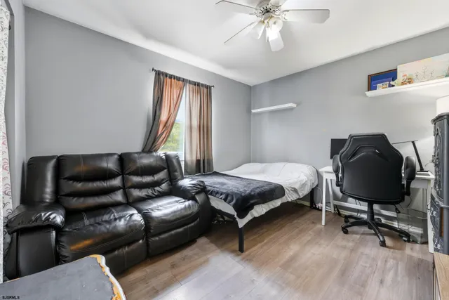 a bedroom with a bed wooden floor and lamp