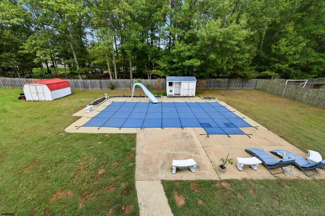 a view of a house with swimming pool and a yard
