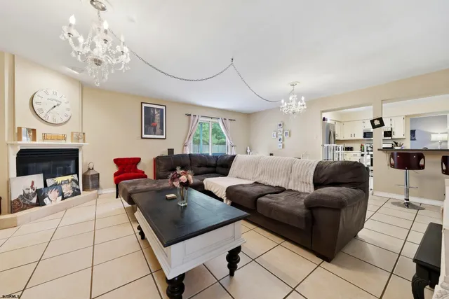 a living room with furniture a fireplace and a chandelier