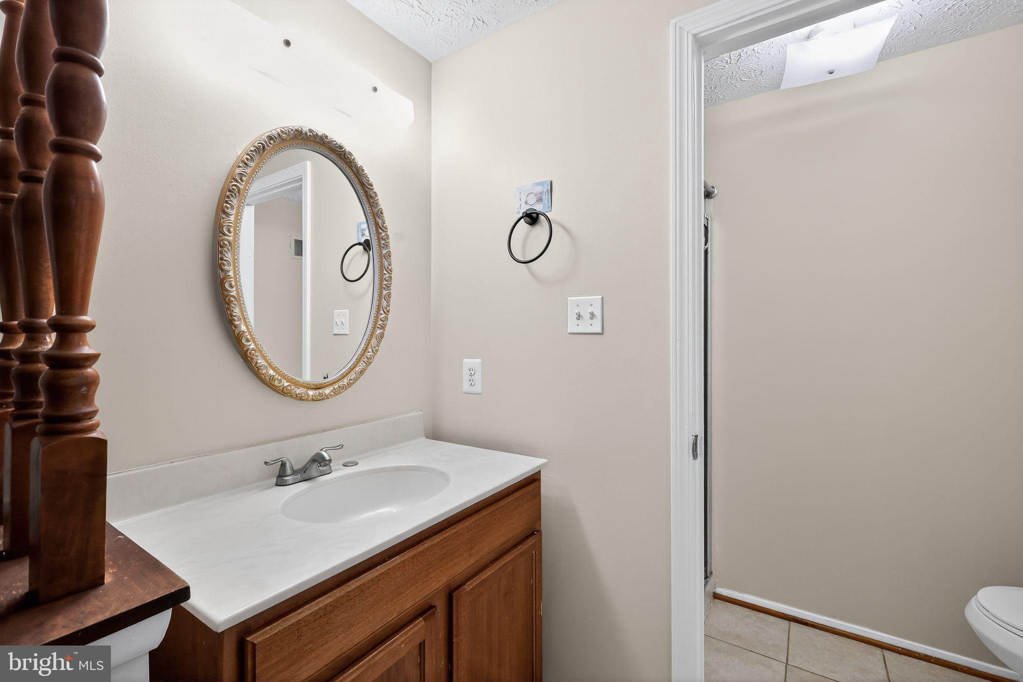 3602 Castle Terrace, Unit 116102 Silver Spring, MD 20904 - Photo 25 of 30 a bathroom with a sink a toilet and a mirror