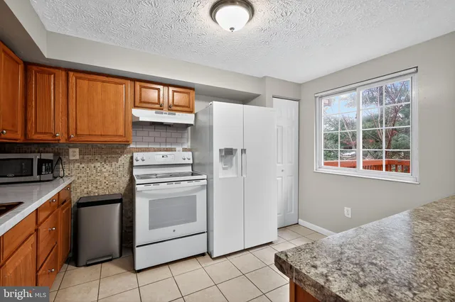 a kitchen with granite countertop cabinets and window