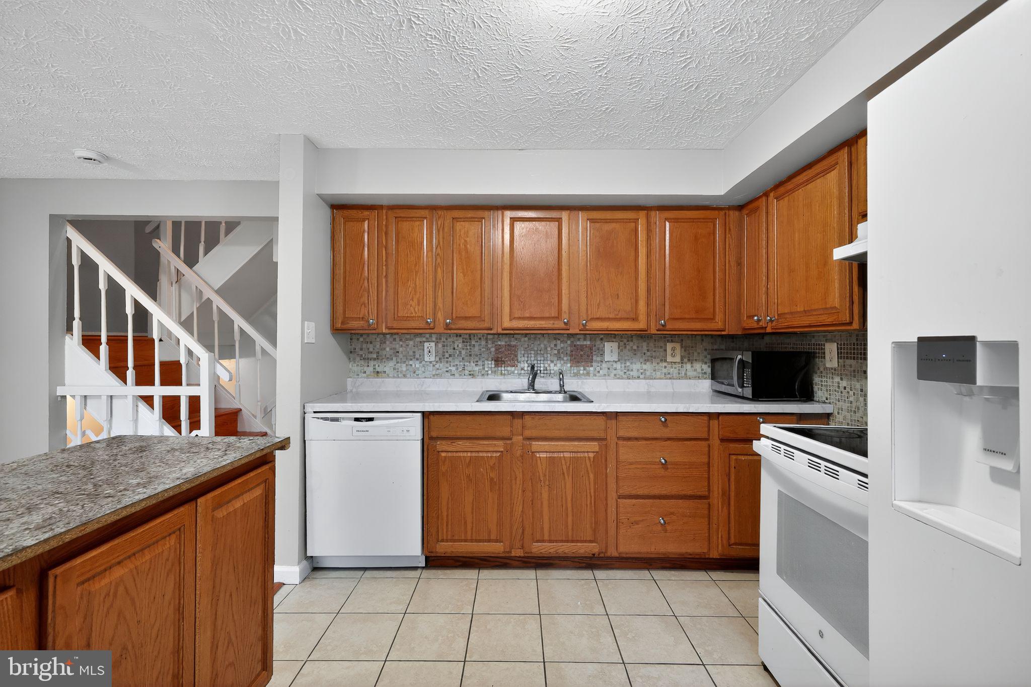3602 Castle Terrace, Unit 116102 Silver Spring, MD 20904 - Photo 7 of 30 a kitchen with a stove top oven sink and cabinets