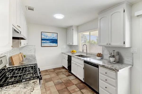 a kitchen with granite countertop a stove a sink and a granite counter tops