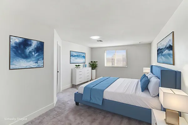 a spacious bedroom with a bed and a painting on the wall