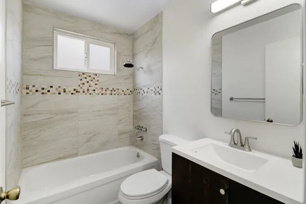 a backyard of a house with large trees and a wooden fence