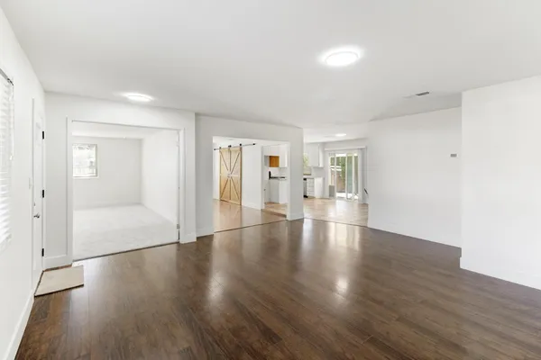 a view of a kitchen with wooden floor and a window