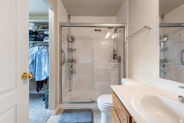 802 Brookside Court Payson, UT 84651 - Photo 25 of 32 Full bath featuring vanity, a spacious closet, a shower stall, and light tile patterned floors