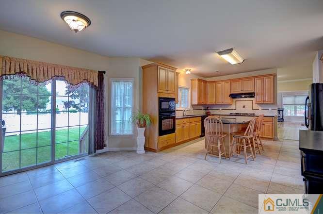 2 Banko Farm Road Dayton, NJ 08810 - Photo 7 of 24 a kitchen with stainless steel appliances granite countertop a stove top oven a sink a dining table and chairs