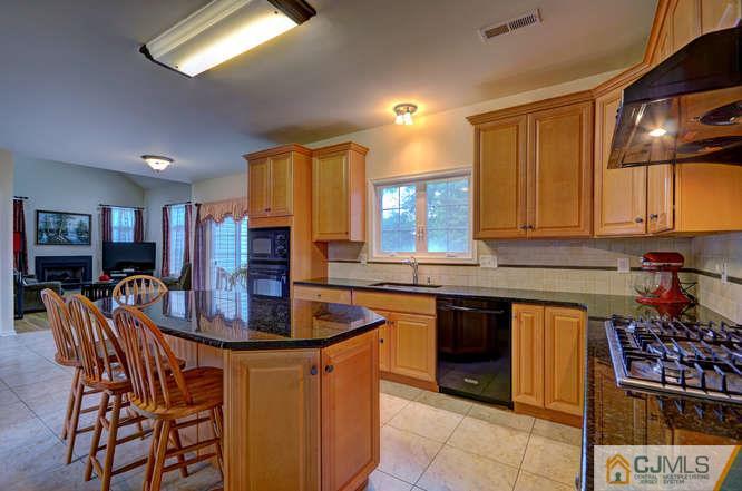 2 Banko Farm Road Dayton, NJ 08810 - Photo 9 of 24 a kitchen with stainless steel appliances granite countertop a stove top oven a sink a dining table and chairs