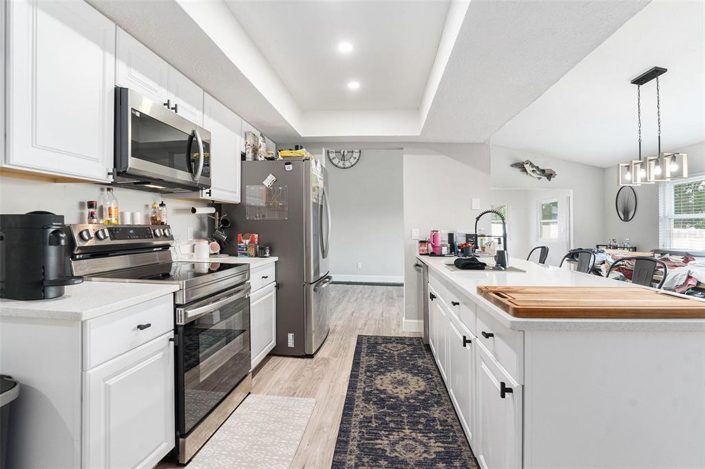 10234 Bedford Road Spring Hill, FL 34608 - Photo 13 of 31 a kitchen with stainless steel appliances granite countertop a sink stove and refrigerator