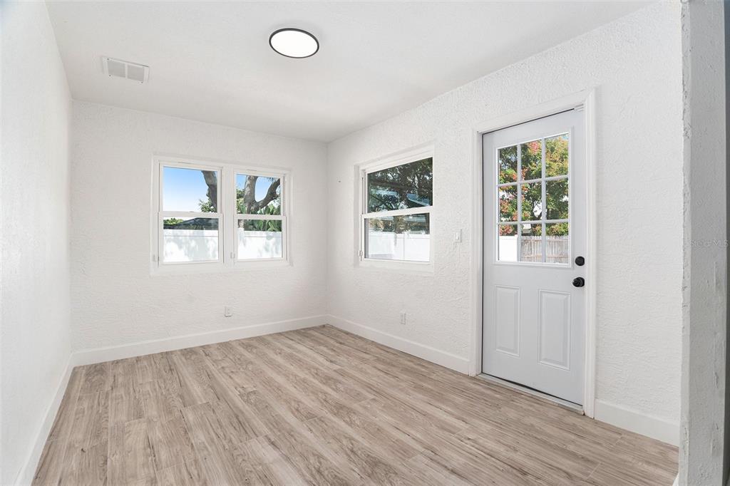 10234 Bedford Road Spring Hill, FL 34608 - Photo 16 of 31 an empty room with wooden floor and windows