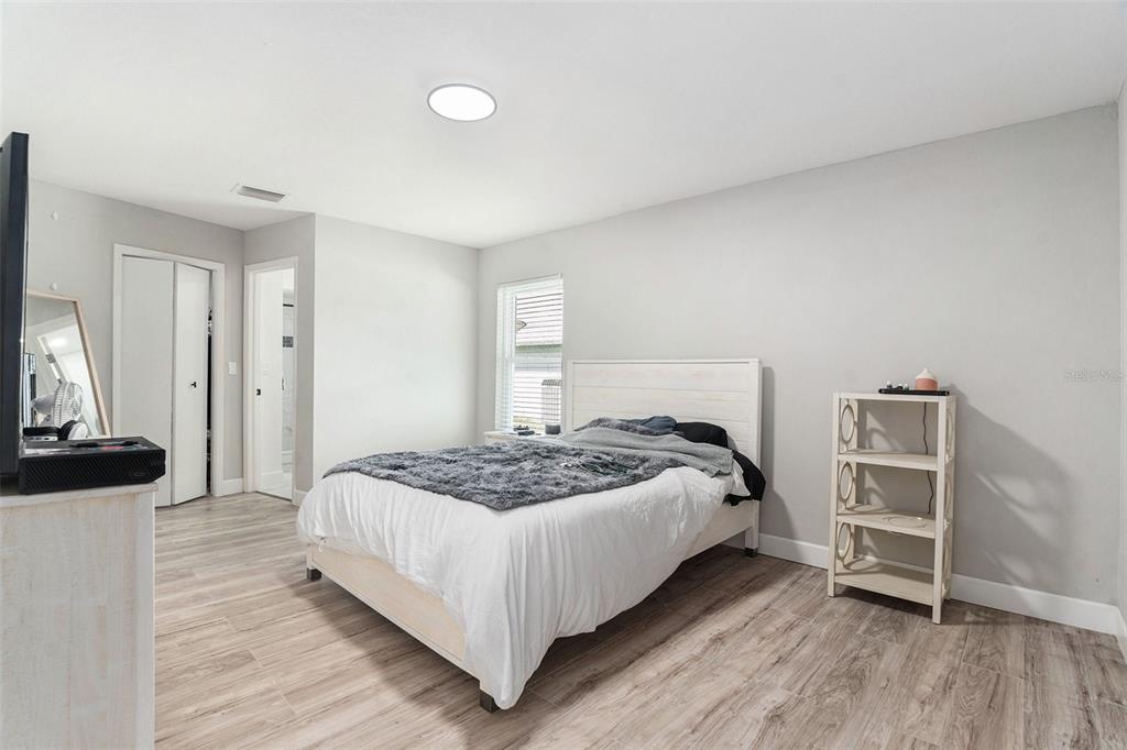 10234 Bedford Road Spring Hill, FL 34608 - Photo 19 of 31 a bedroom with a bed and a flat tv screen on a dresser