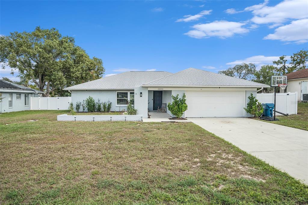 10234 Bedford Road Spring Hill, FL 34608 - Photo 2 of 31 a front view of a house with garden
