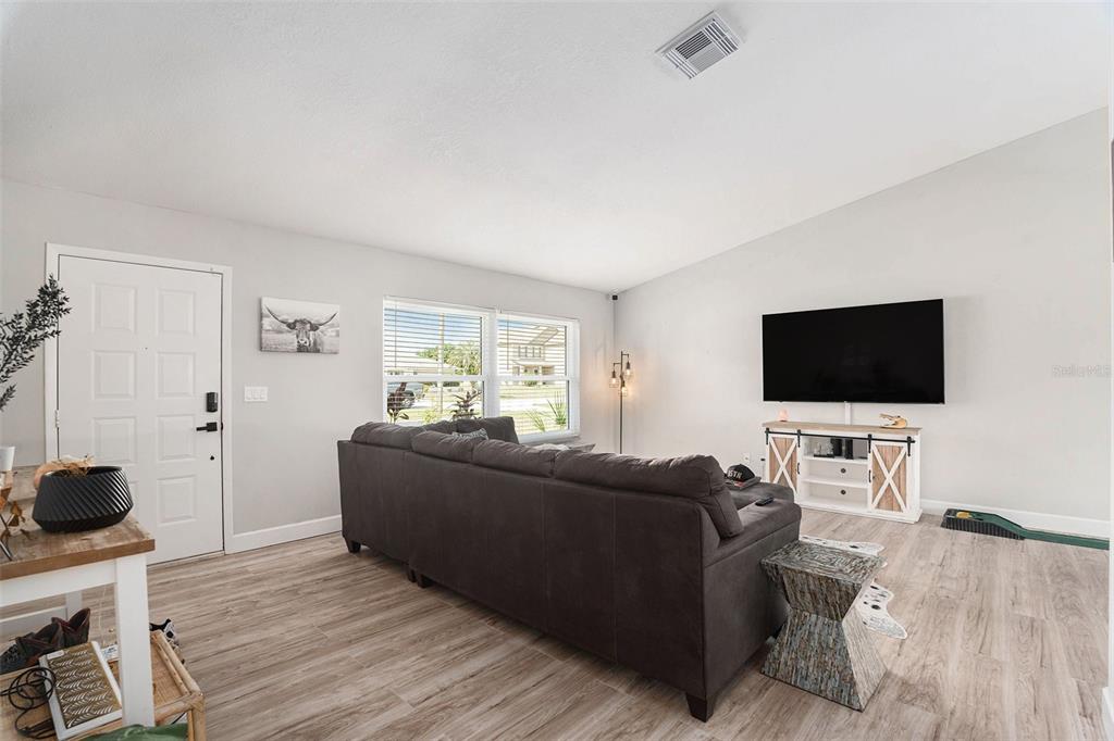 10234 Bedford Road Spring Hill, FL 34608 - Photo 6 of 31 a living room with furniture and a flat screen tv