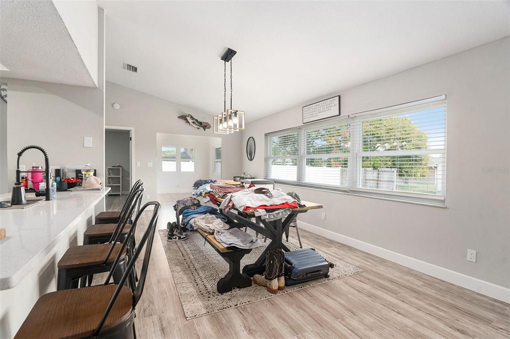 10234 Bedford Road Spring Hill, FL 34608 - Photo 9 of 31 a view of a dining room and livingroom with furniture wooden floor a chandelier