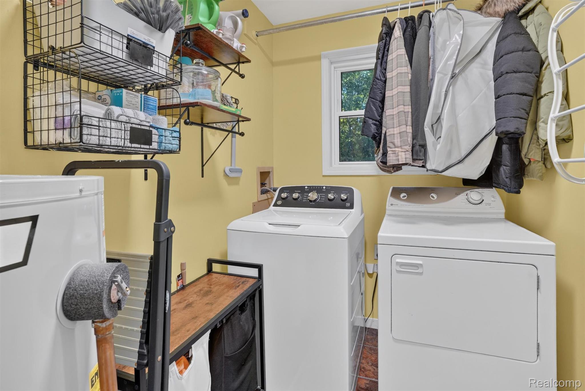 8696 West Sargent Road Fowlerville, MI 48836 - Photo 25 of 36 Dedicated laundry area featuring a window, built-in shelving, a clothes rod, and tile flooring