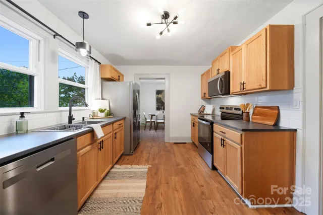 a kitchen with stainless steel appliances granite countertop a sink a stove and a refrigerator