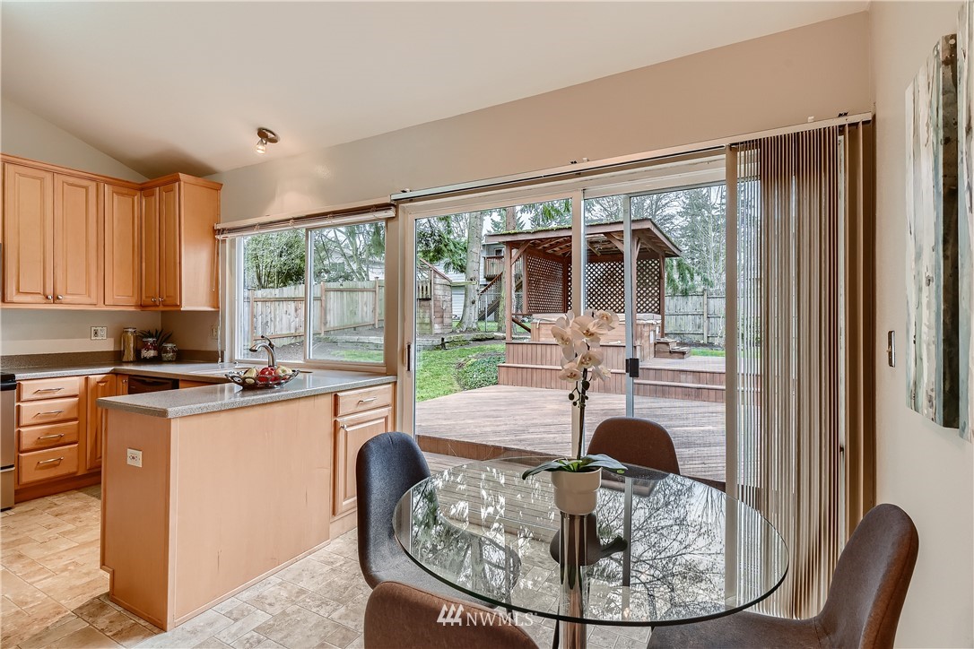 706 221st Street Southwest Bothell, WA 98021 - Photo 12 of 27 a dining room with furniture a fireplace and large windows