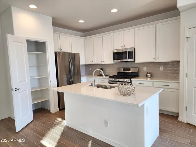 a kitchen with stainless steel appliances a refrigerator sink and microwave