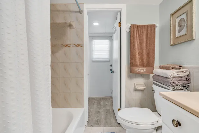 a bathroom with a granite countertop toilet a sink and shower